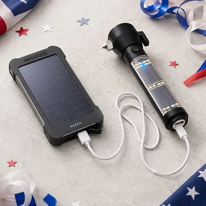 A patriot power cell power bank charging a HaloXT tactical solar flashlight with confetti and an American flag for the 250th celebration 