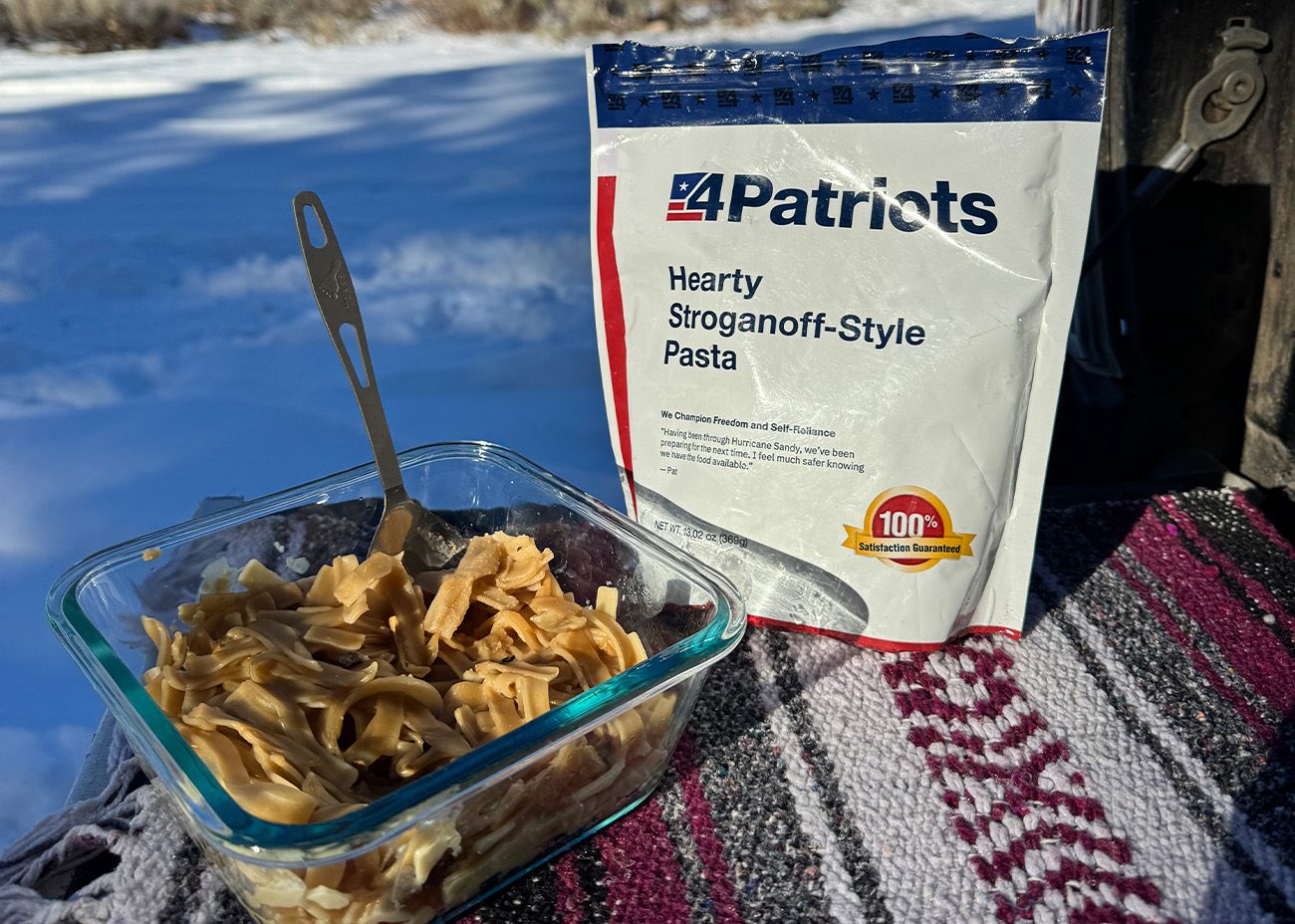 Hearty Stroganoff-Style Pasta A bowl of Hearty Stroganoff on a truck tailgate next to a pouch of food.