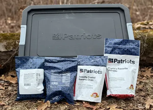 The 4Patriots 3-Month Survival Food kit displayed in the woods during fall time.