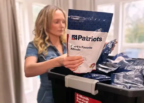 A woman unpacking the 4Patriots 3-Month Survival Food Kit in her home.