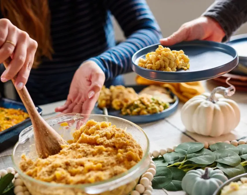 A casserole dish being passed across a dinner table filled with tasty-looking 4Patriots emergency food.