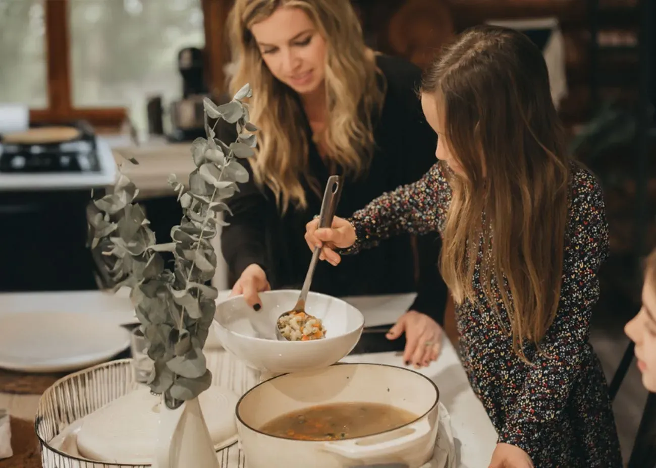 A person cooking food on a portable stove during a blackout, surrounded by emergency supplies like canned goods and bottled water. The scene is dimly lit, emphasizing preparedness in a power outage.