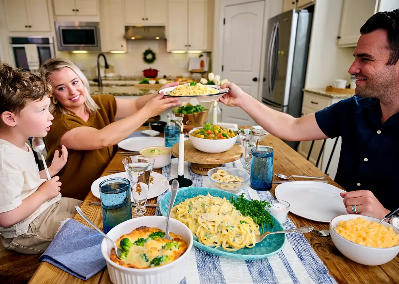 A mother, father and young son enjoying a full, nutritious pasta dinner prepared from a 4-week emergency food supply.