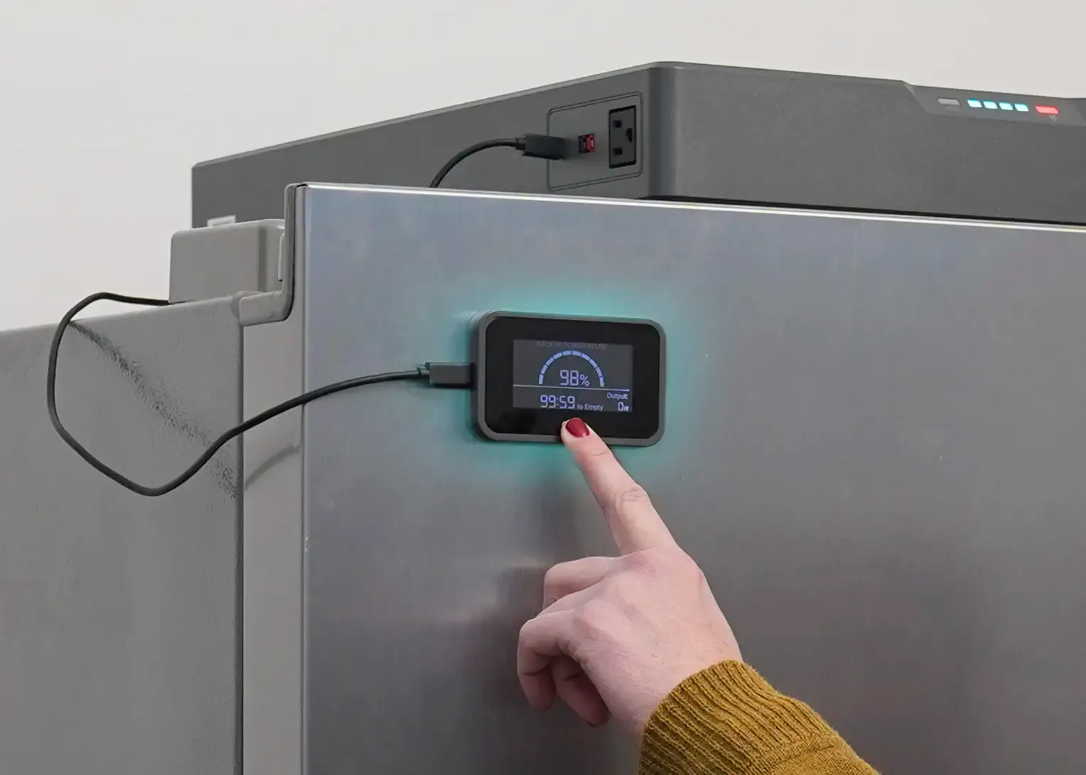 A retro camper van with a wooden pop-top roof is parked on grassy land with its side door open. In front of it, a portable solar panel and 4Patriots power station are set up, showcasing off-grid energy for van life and outdoor living.