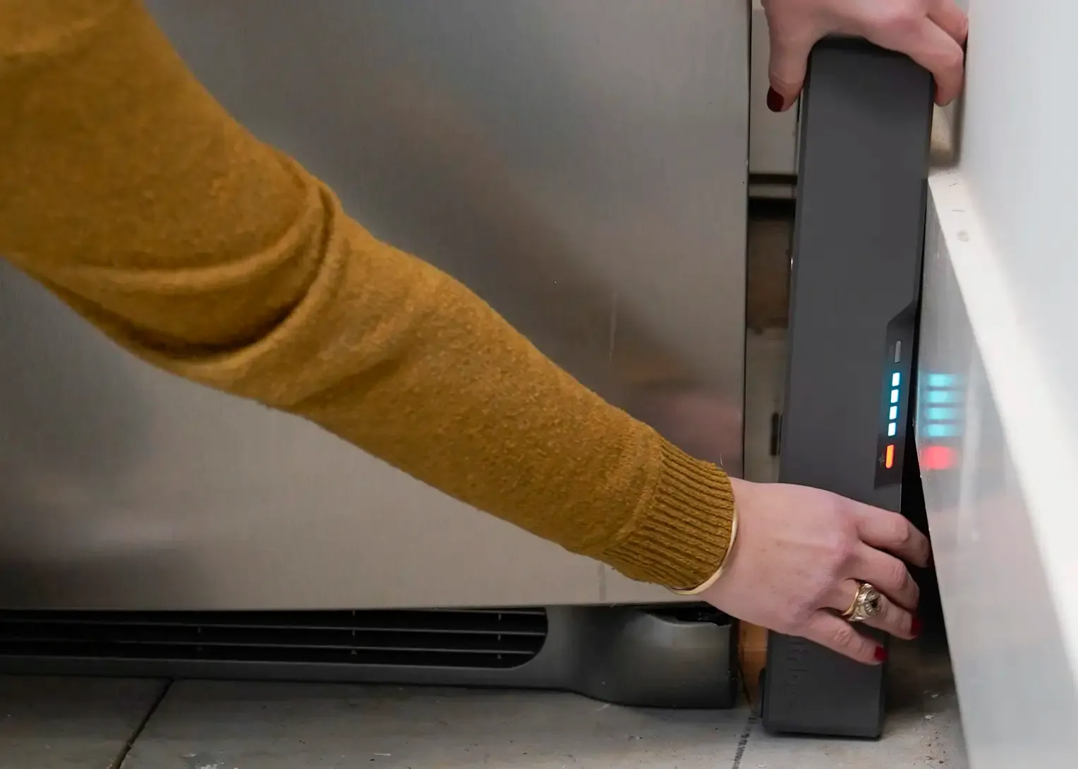 A man uses a power saw connected to a 4Patriots generator with an external battery pack. The setup is on a wooden porch, showing the generator powering heavy-duty tools for off-grid work.