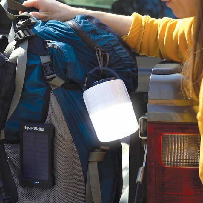 A Patriot Power Cell-CX Power Bank and SoLantern attached to a backup sitting on a truck bed.