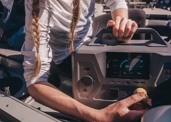 A woman using the 4Patriots Patriot Power Generator 1200 in a fishing boat.