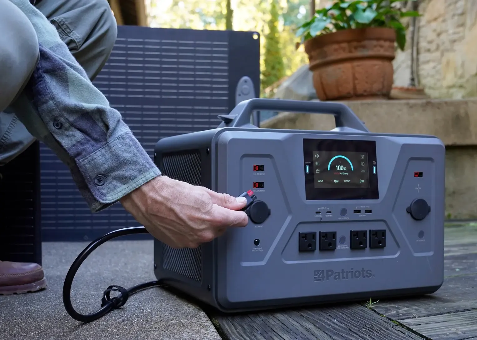 Patriot Power Solar Generator 2500X powering tools A man uses a power saw connected to a 4Patriots generator with an external battery pack. The setup is on a wooden porch, showing the generator powering heavy-duty tools for off-grid work.