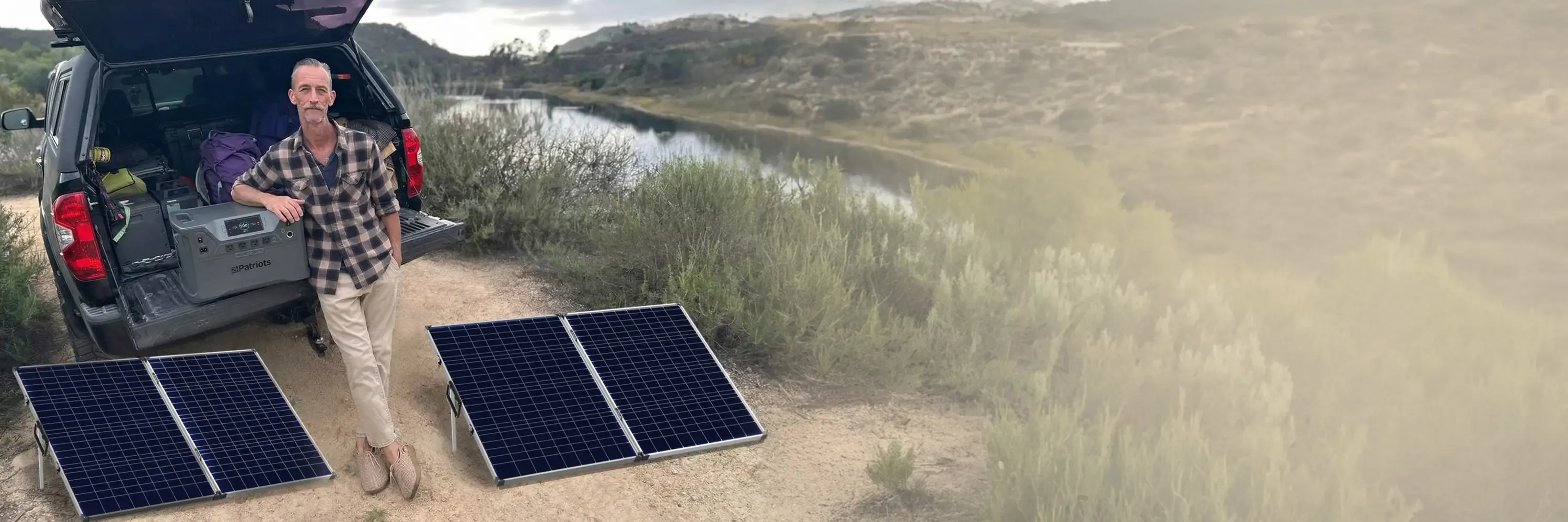 A man with his Patriot Power Solar Generator 2500X in the bed of his SUV with 2 Free Solar Panels
