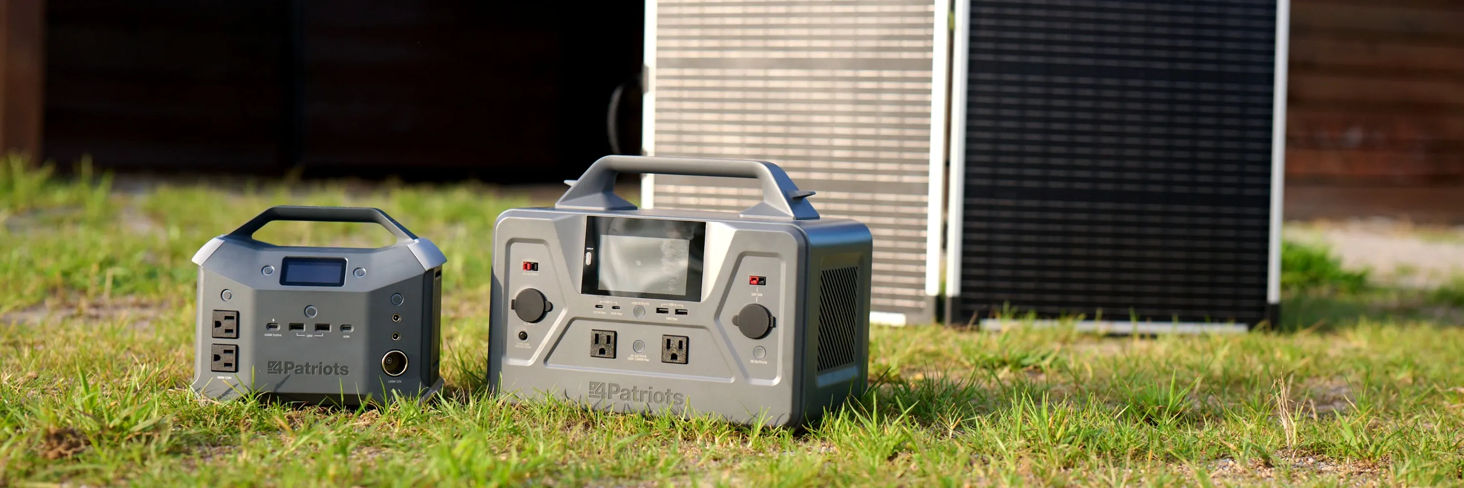 Compact and full-size 4Patriots portable power stations on grass beside a foldable 100-Watt solar panel for off-grid backup power