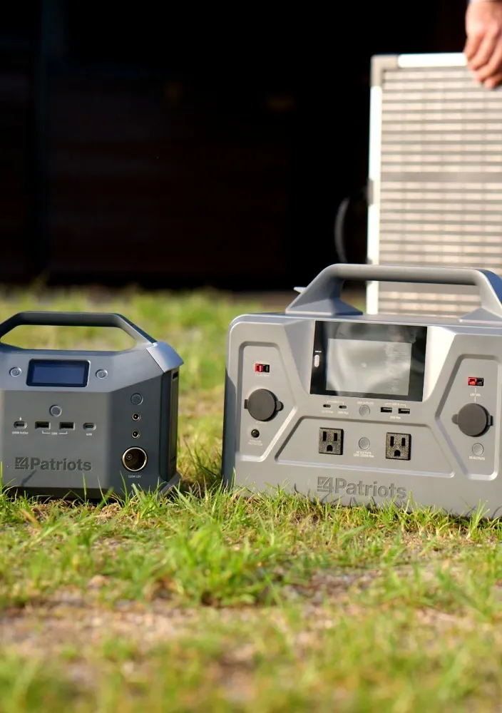 Man setting up a 4Patriots folding solar panel behind two portable power stations for off-grid solar power