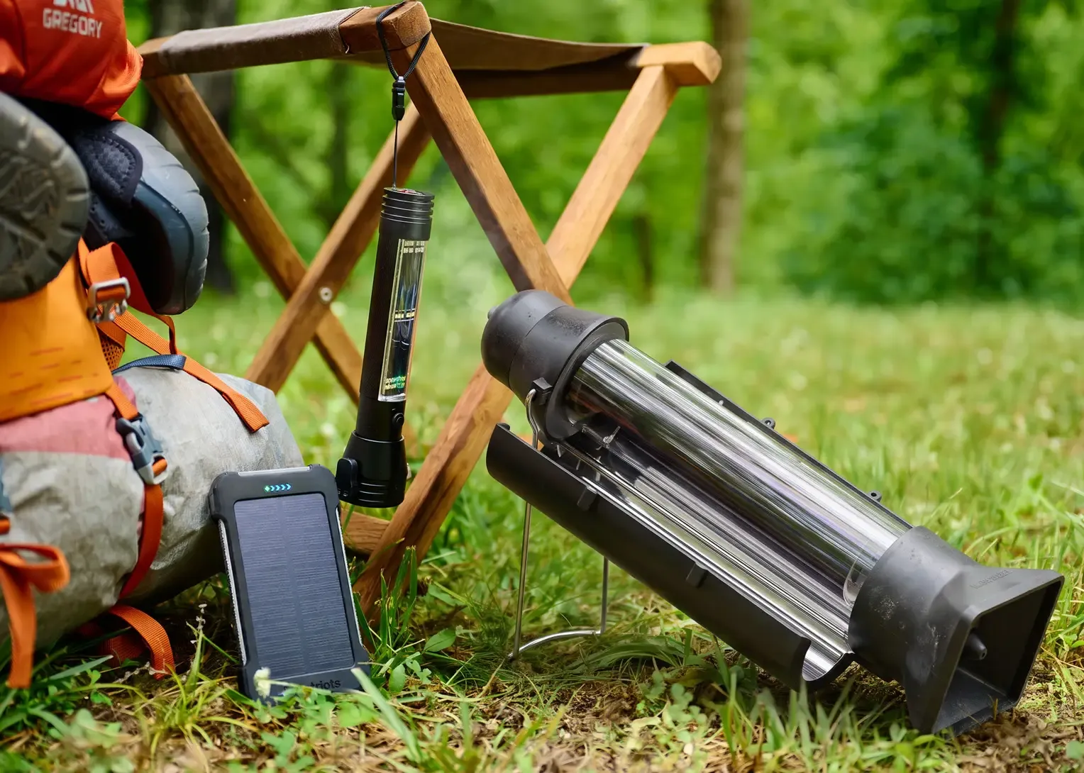 A Patriot Power Cell Bank, HaloXT Flashlight, and Sun Kettle Solar Heater at a campsite